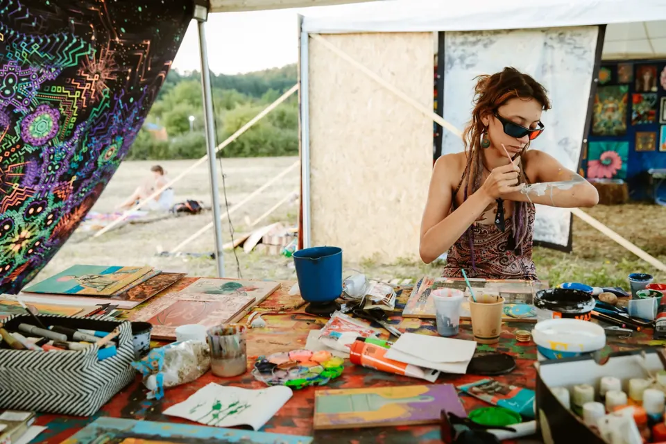 An artist painting at a craft table in the Art Zone