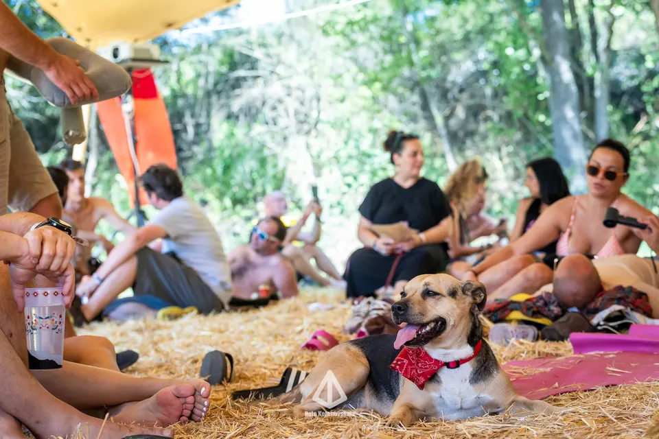 Friends sitting on straw with a dog in a bandana