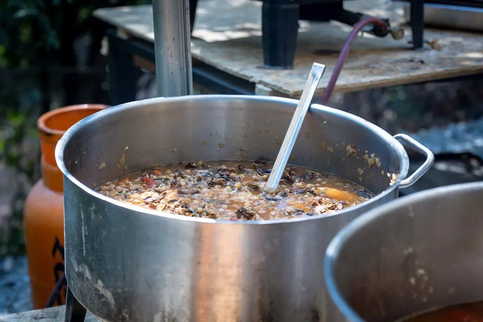 A large pot of food cooking in the community kitchen