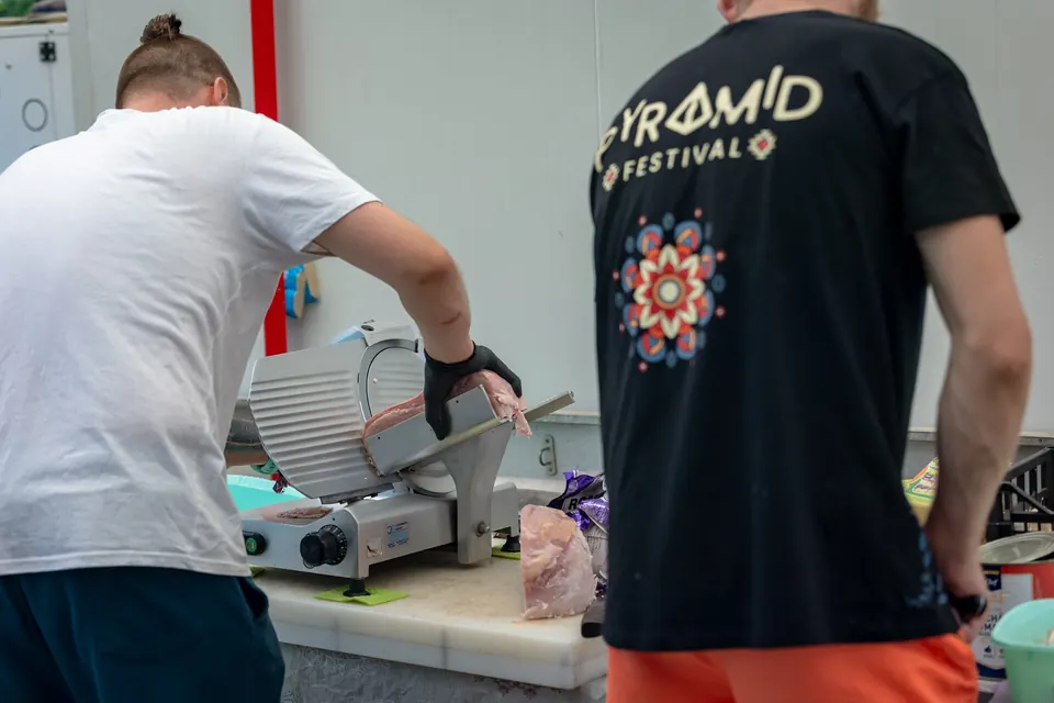 Crew cooking in the kitchen in a Pyramid Festival shirt