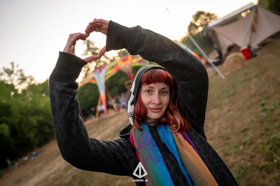A woman in a wool hoodie making a heart with her hands