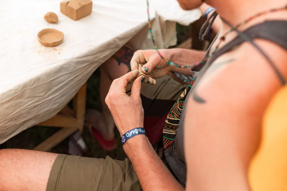 Hands shaping clay at a workshop