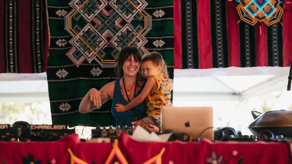 A DJ playing with her child at Healing Days