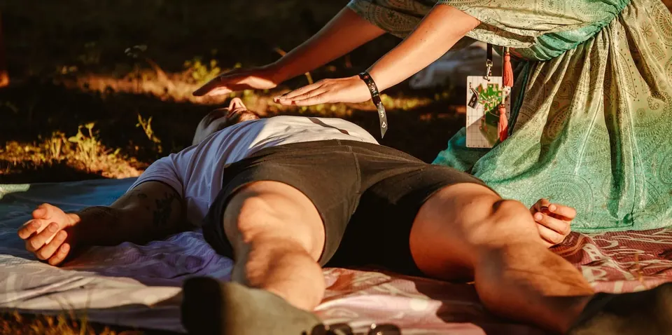 An energy healing session on a mat