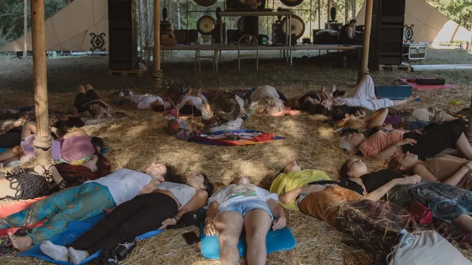 People lying down for a sound bath in the healing tent