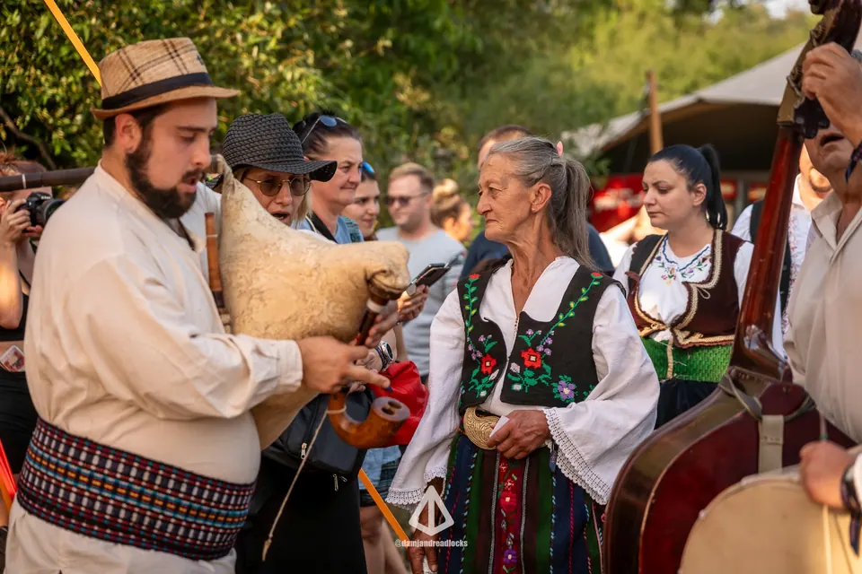 A bagpipe player and singers in folk costume