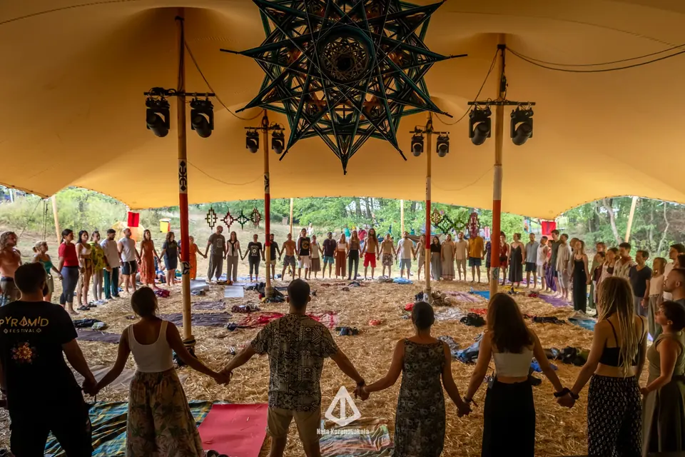 Veliki krug ljudi koji se drže za ruke u festivalskom šatoru na Pyramid Festivalu 2025.
