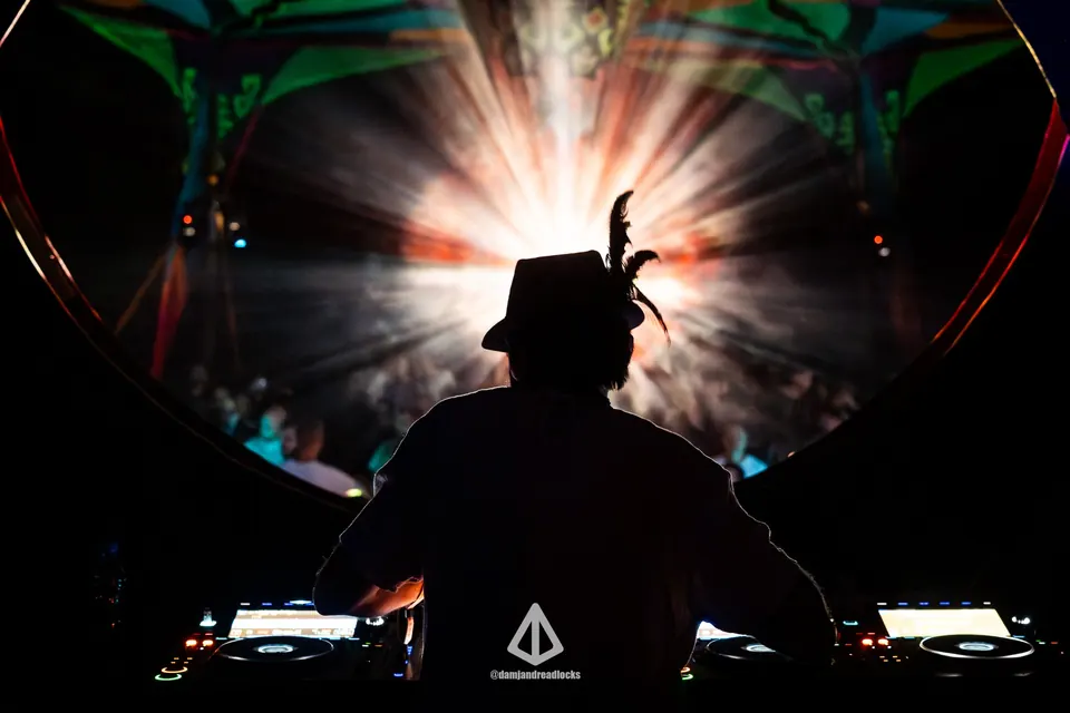 A DJ silhouetted against a burst of light