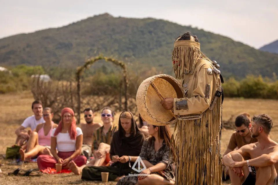 A drum circle next to a carved totem
