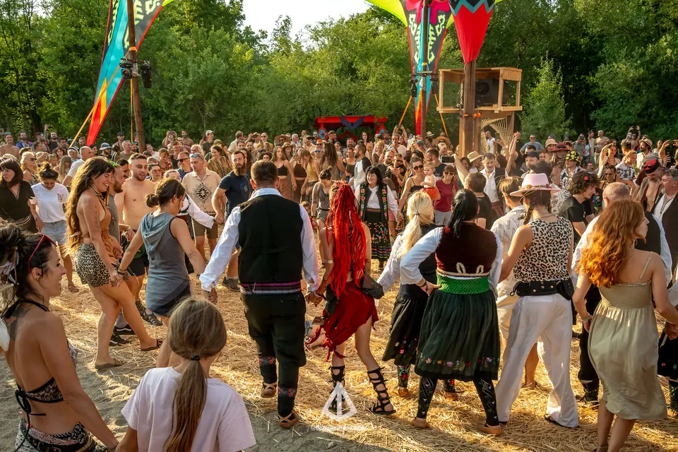 A crowd joins a folk dance on the meadow