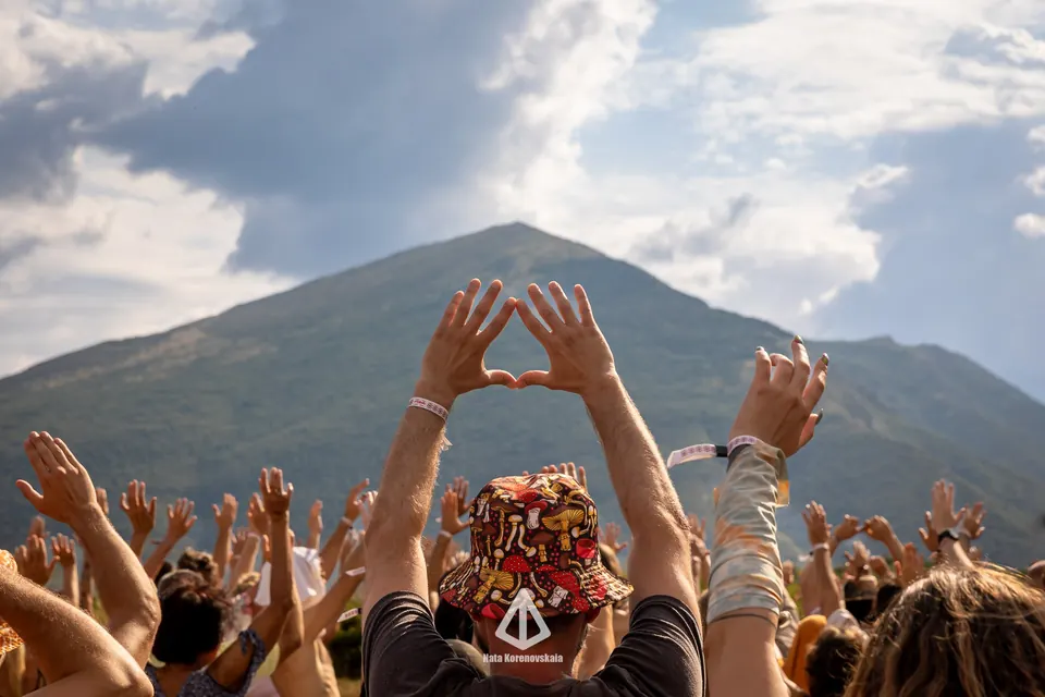 Hands making heart shapes towards Rtanj above the crowd