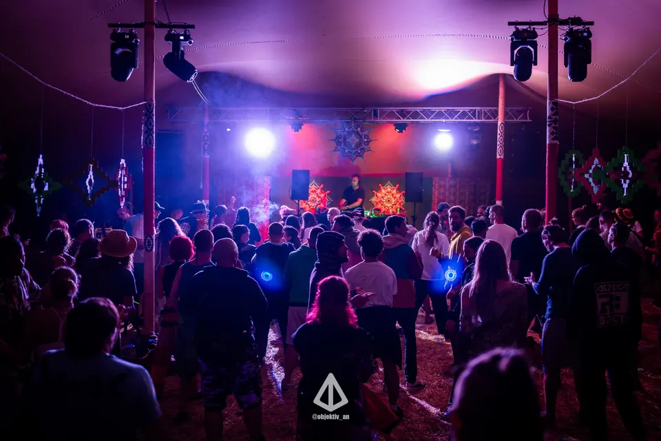 Dancers under purple lights in the tent stage