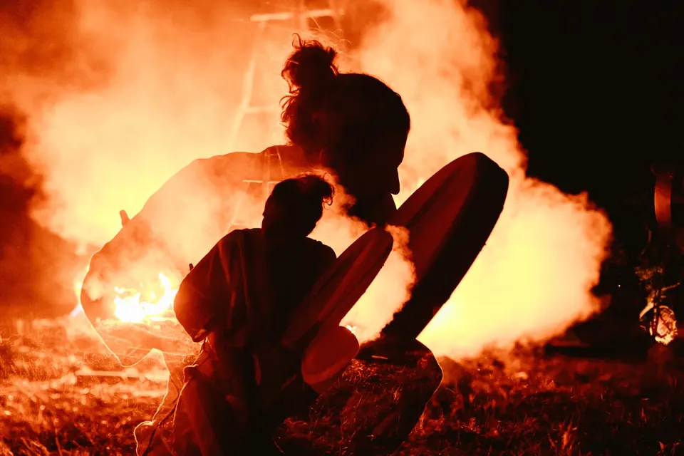 A drummer silhouetted against the fire
