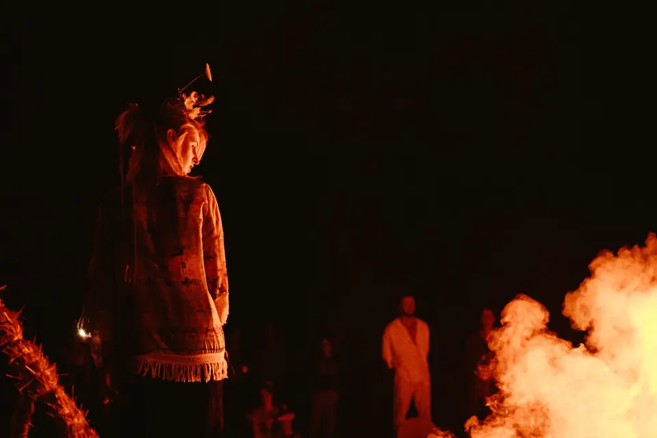 A figure by the fire at night