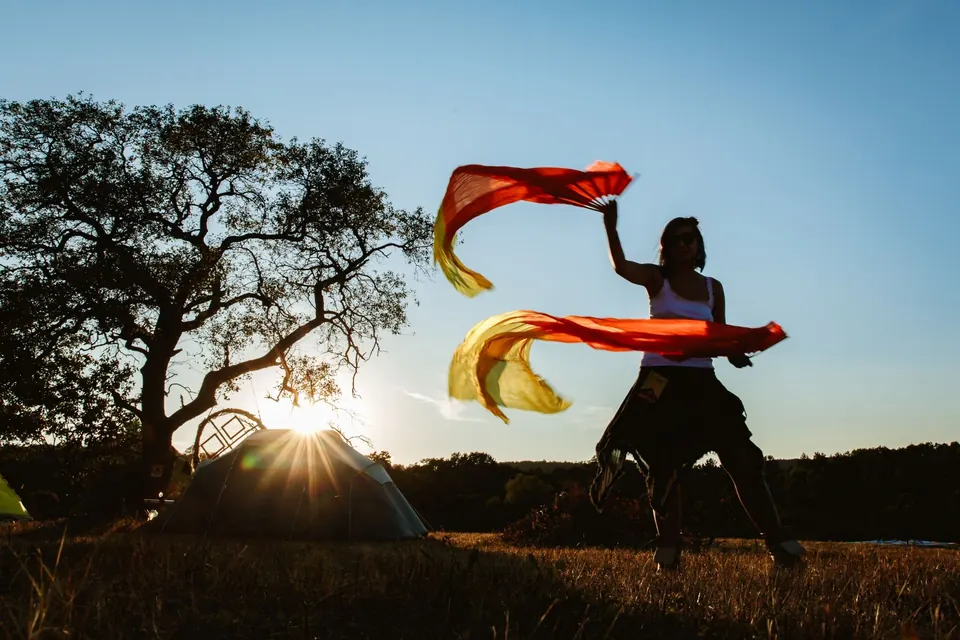 A flag dancer at sunset