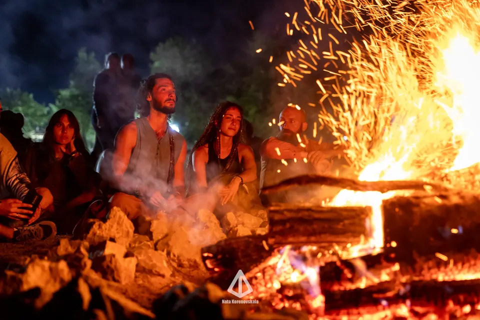 People keeping warm around a large fire on a cold festival night