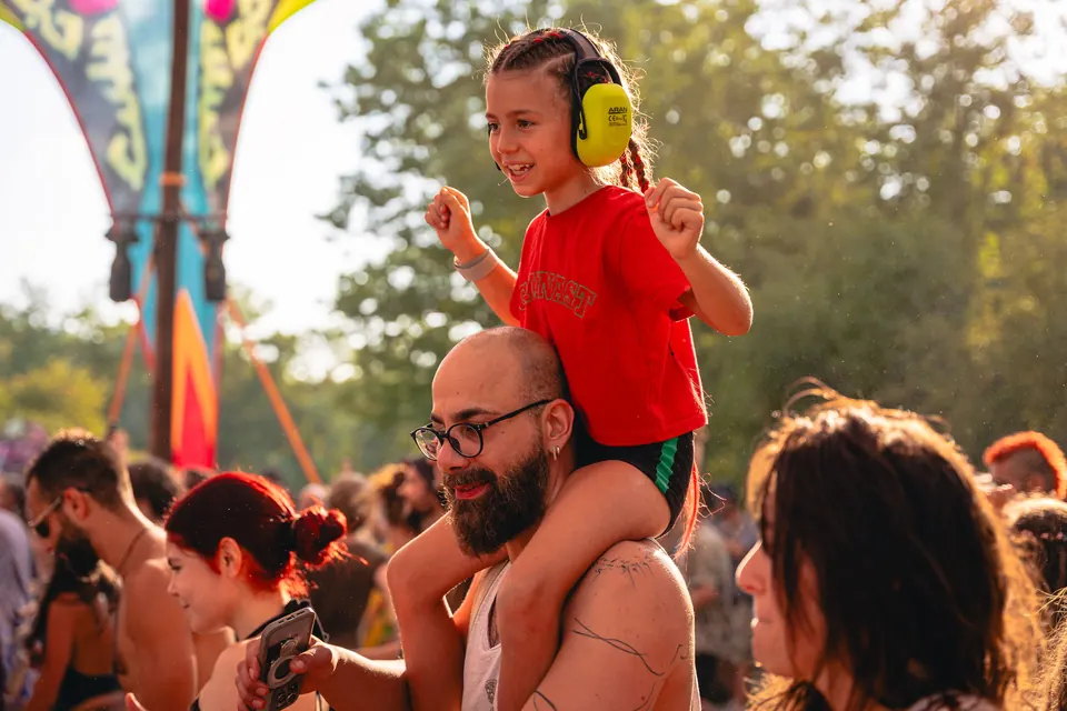 A child on her father's shoulders in the crowd