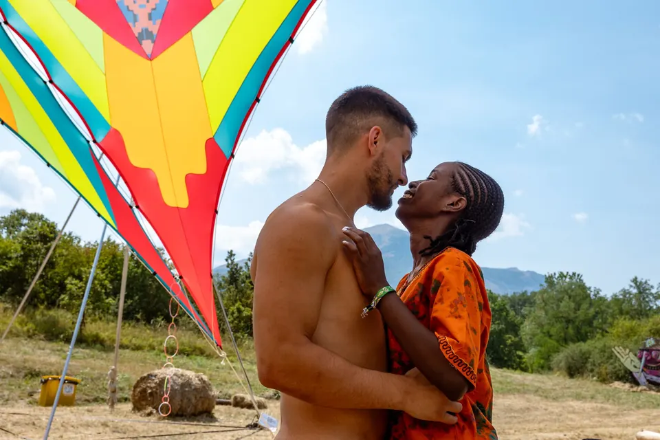 A couple embraces under the sails