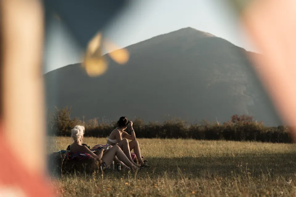 A couple resting in the meadow, Rtanj in the frame
