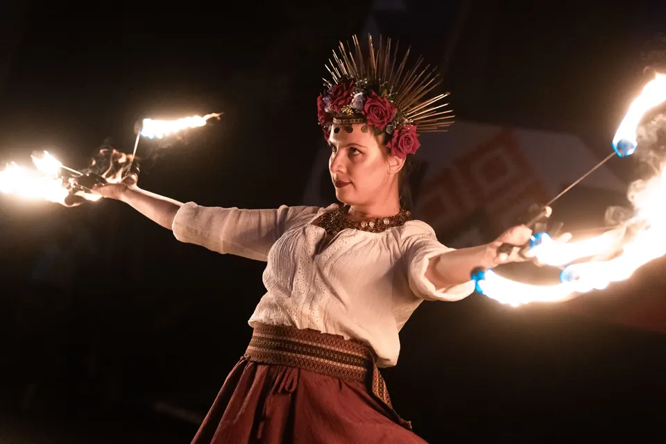 A fire dancer with a sun crown