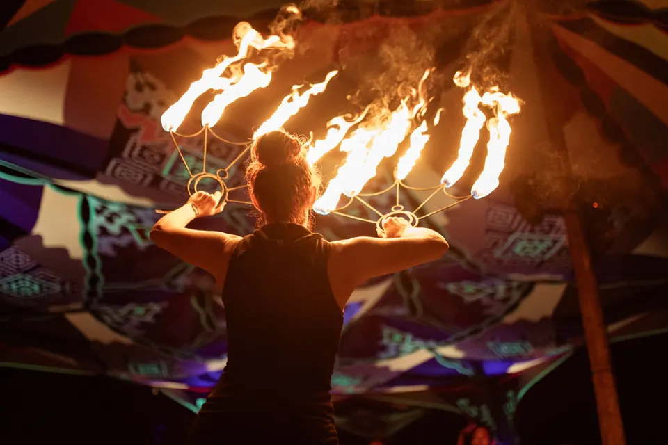 Fire fans seen from behind the performer