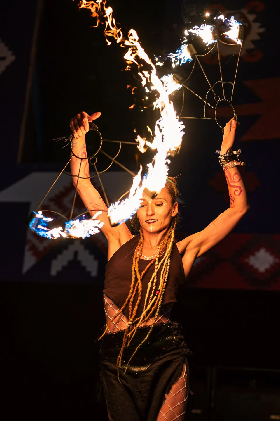 A fire performer with arms raised