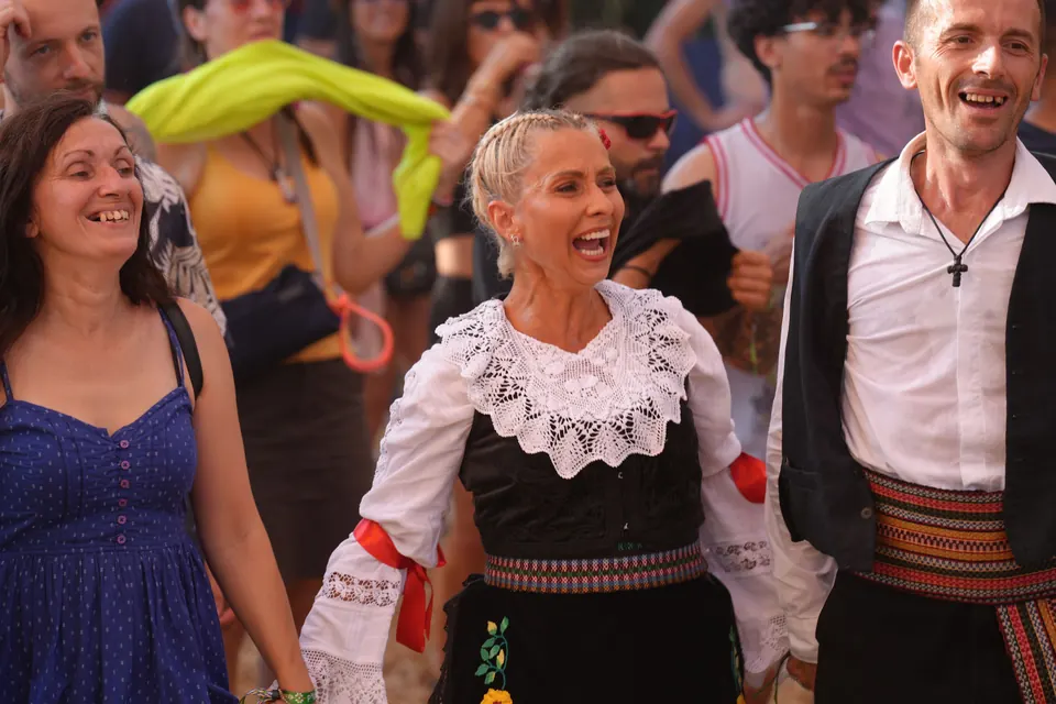 Dancers in folk costume laughing in the crowd