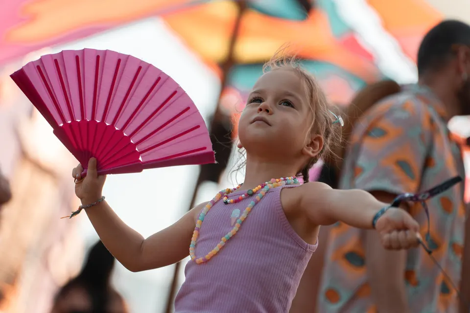 A girl dances with a pink fan