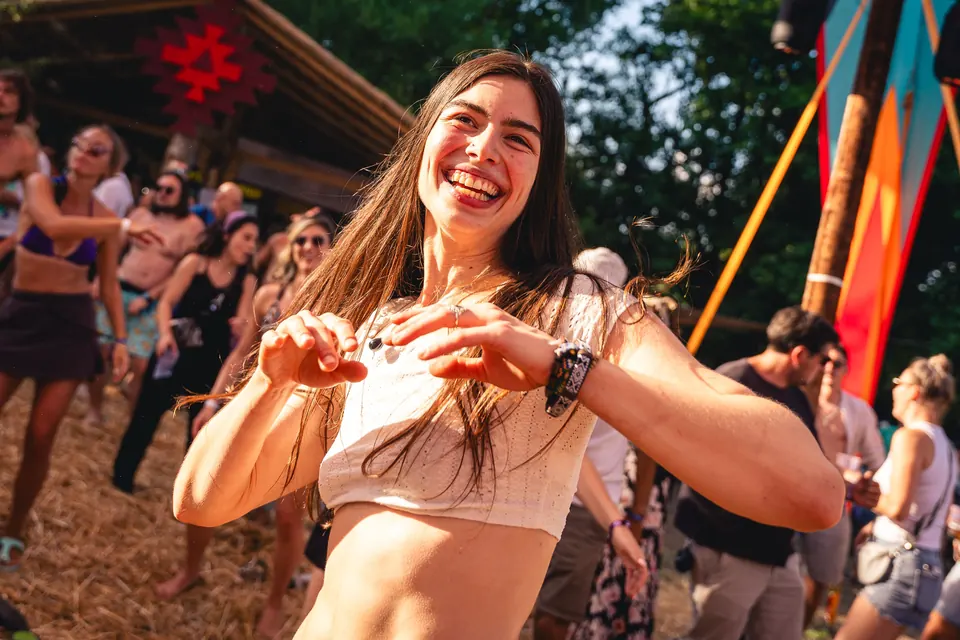 A smiling dancer makes a heart with her hands