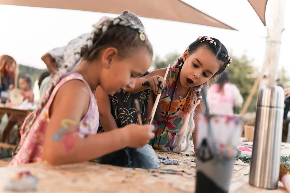 Girls painting at a workshop table