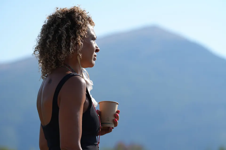 A woman with a cup looks out towards Rtanj