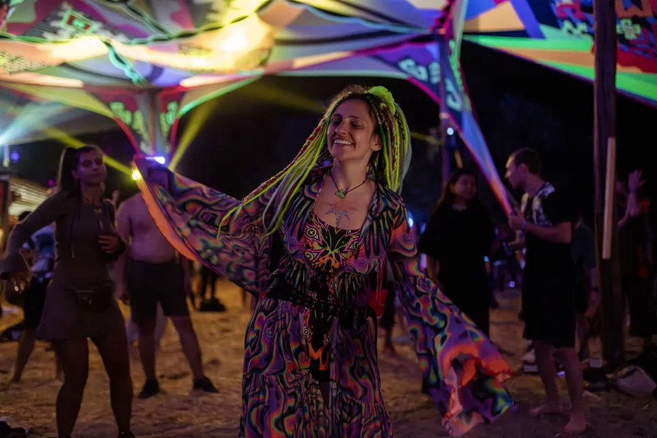 A dancer with neon dreadlocks at night
