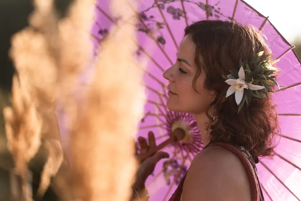 A woman with a pink parasol in the tall grass