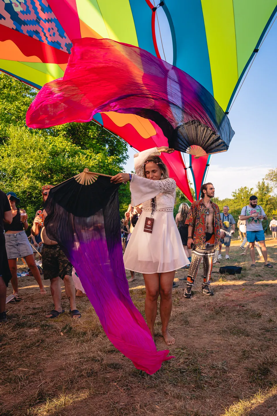 A dancer with flowing silks under the colourful sails
