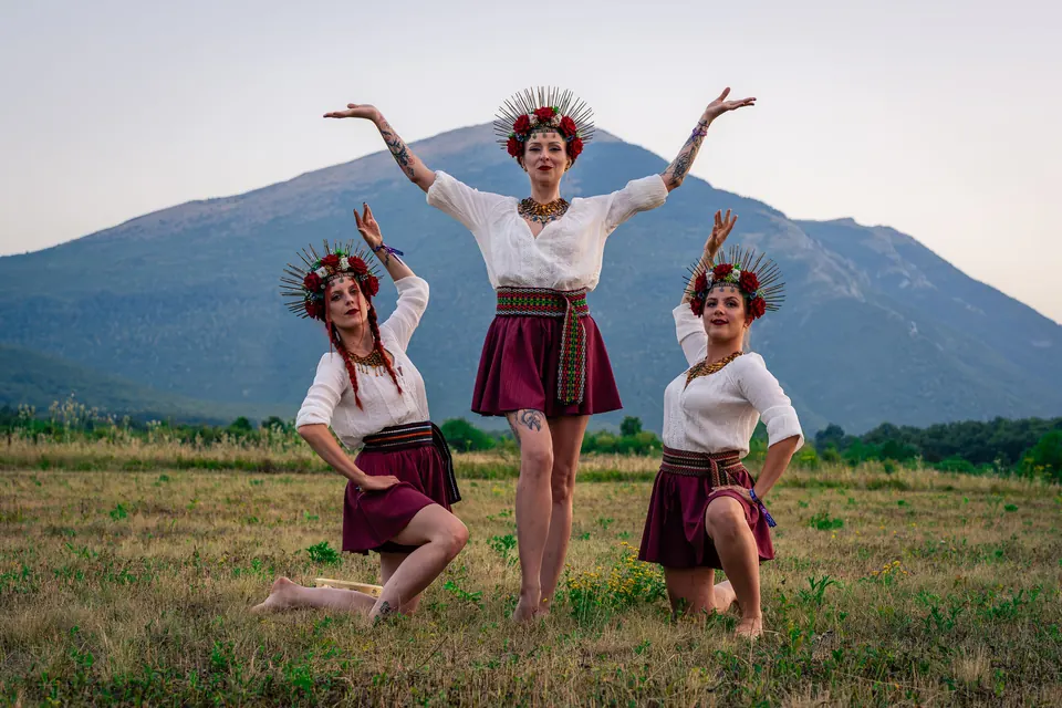 Three dancers in folk costume below Rtanj