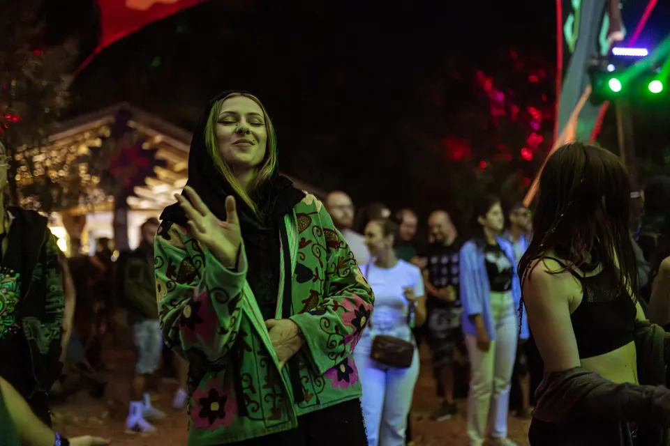 A smiling dancer in the crowd at night