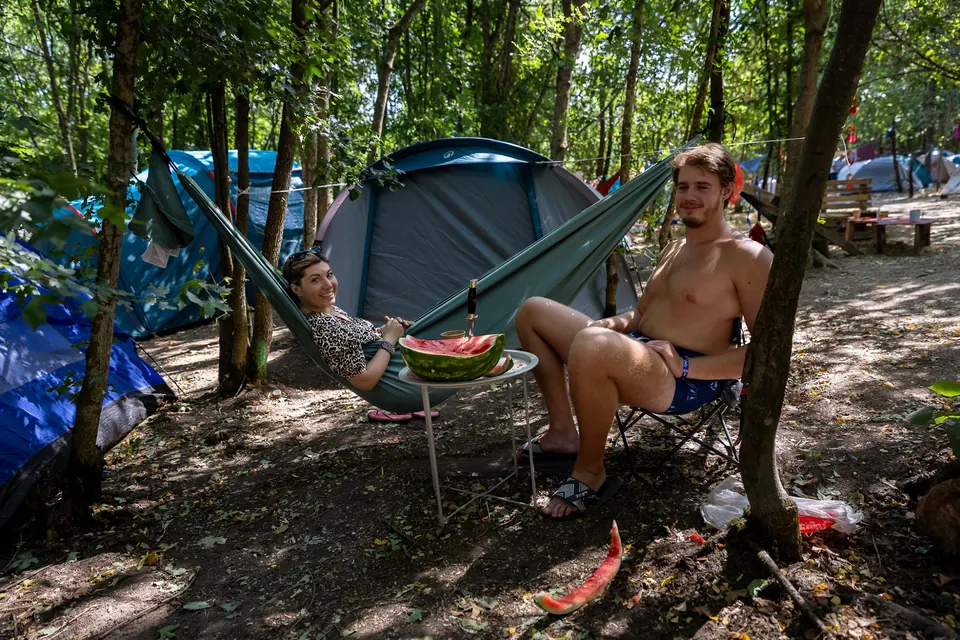 Tents and a hammock in the shaded forest camp