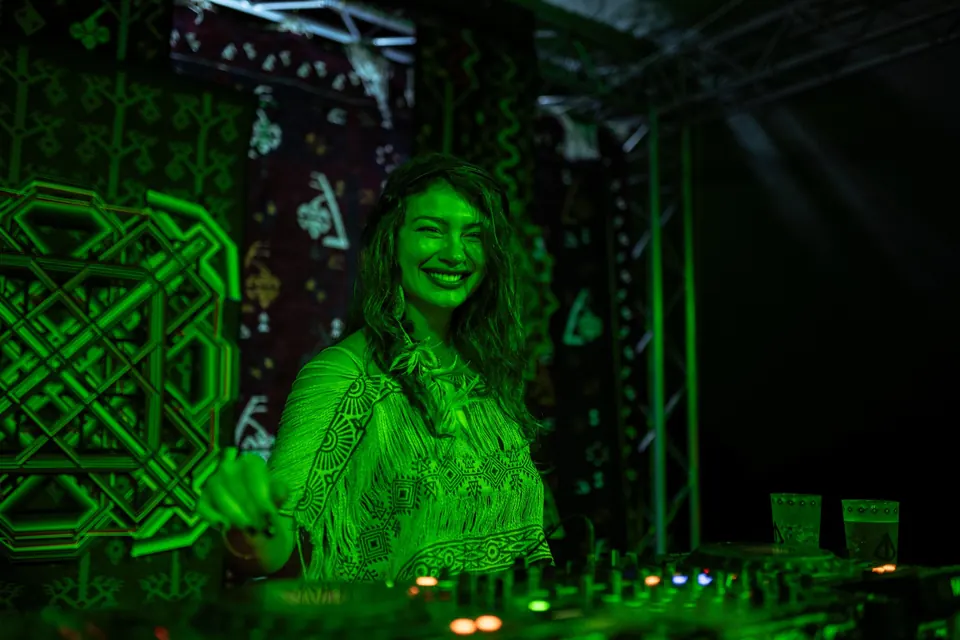 A DJ in green light in front of the TOK ćilim