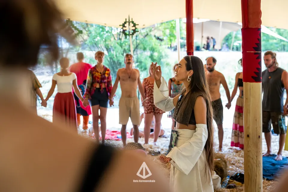 A workshop group standing in a circle holding hands